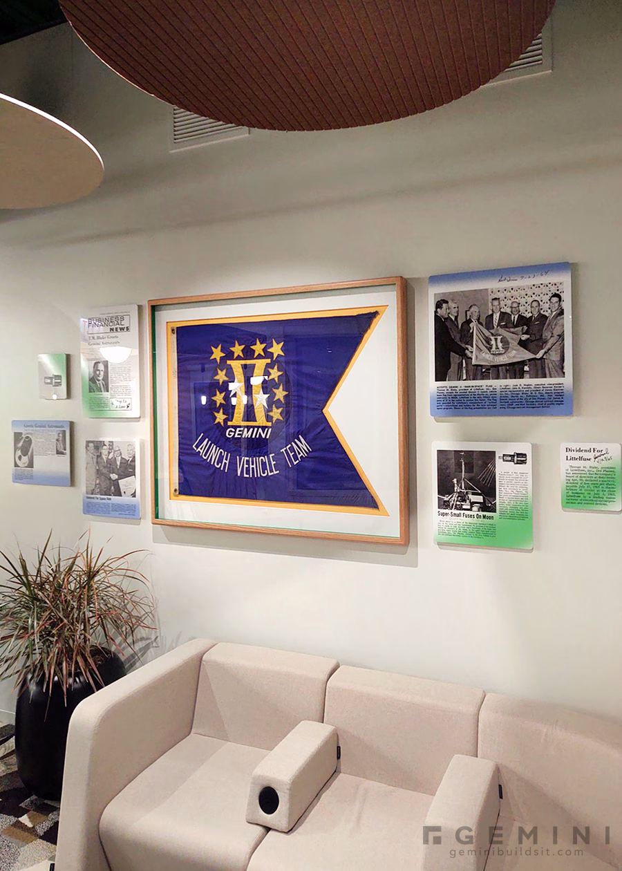 Littelfuse lounge with a custom-framed Gemini flag and floating acrylic panels displaying the company’s Space Race history.