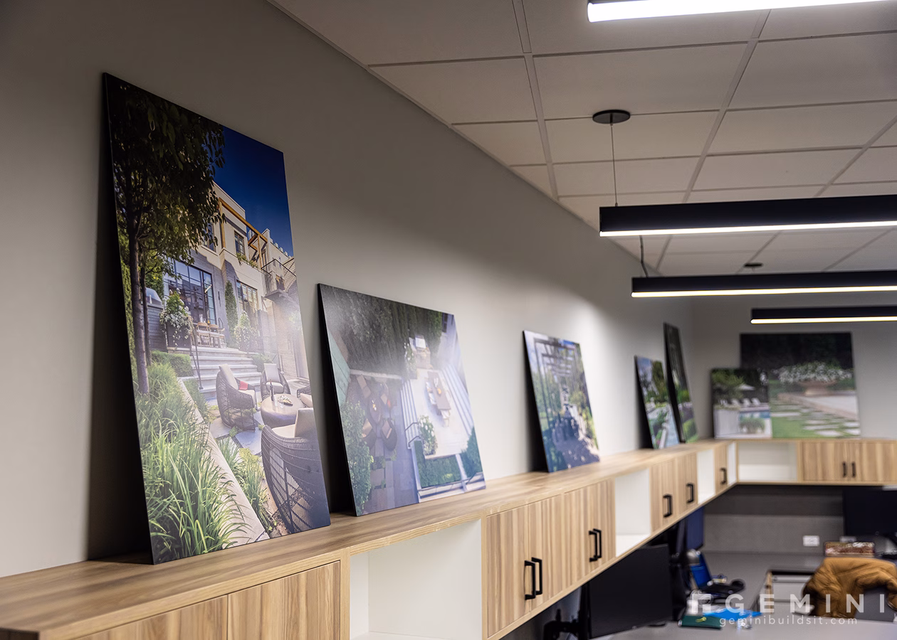 Custom office artwork including direct-printed Sintra panels featuring Mariani landscape projects displayed along office cabinetry